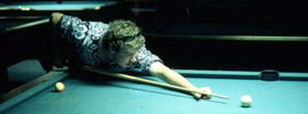Guy playing pool at Cue's Billiards in Marietta A man lining up a shot on one of Cue's regulation pool tables